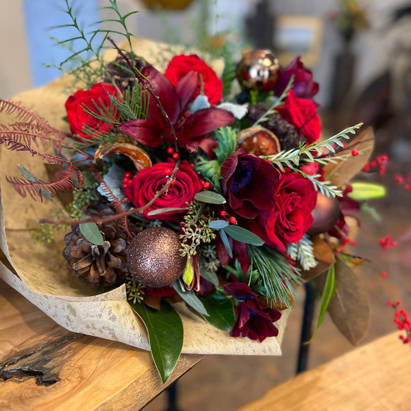 Hand-Wrapped Bouquet featuring Christmas greens and ornaments