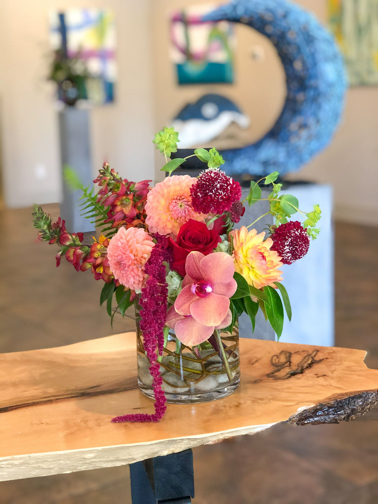 Compact yet brimful, eclectic mix, curly willow & rocks in glass vase